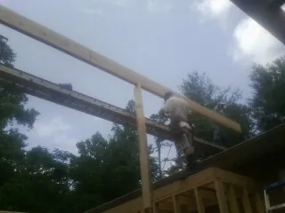 Carpenter setting a ridge beam over a new addition frame — Ice Dam Removal by Roofing Brothers in Hometown