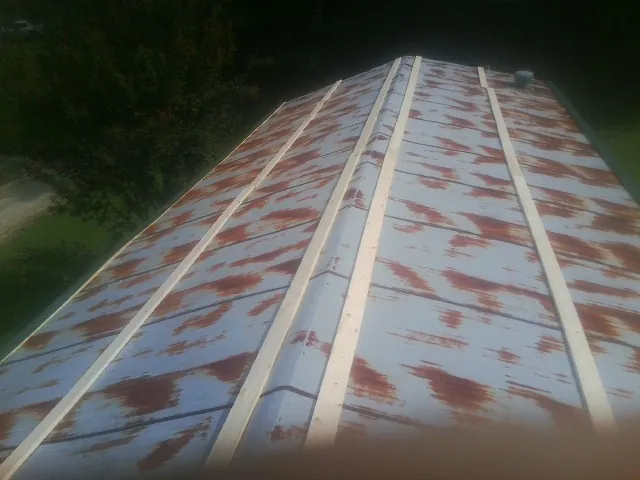 Rusted metal roof panels with new wood purlins before replacement — Storm Damage Roof Repair in Hometown by Roofing Brothers