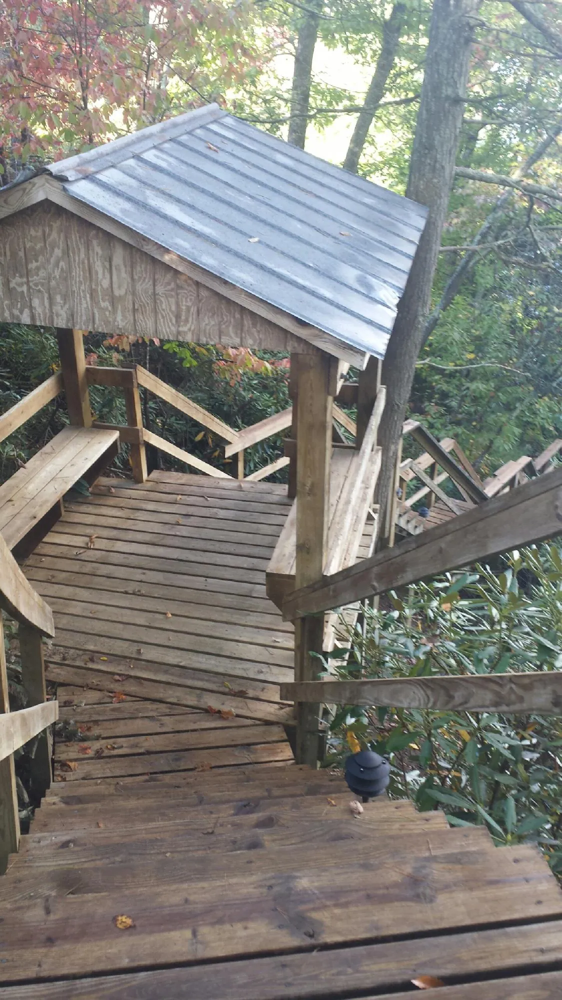 Metal roofed shelter over wooden steps on a wooded walkway — Skylight Repair & Installation work by our crew in Hometown
