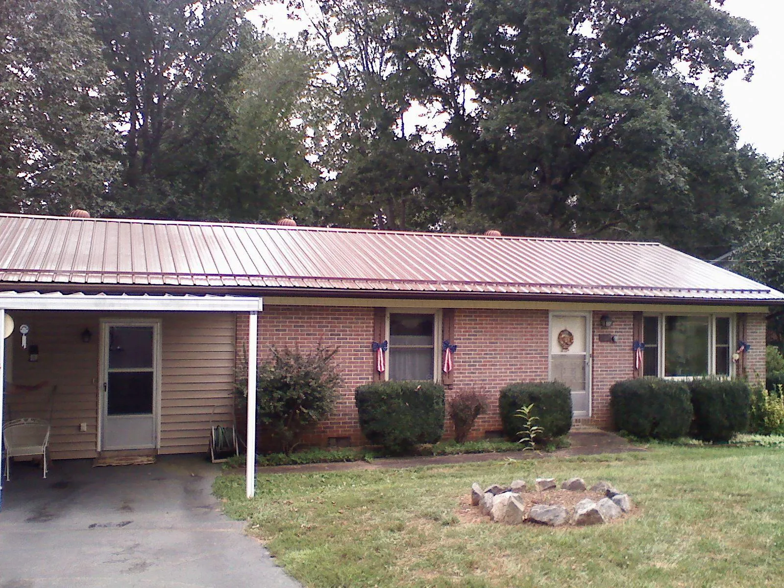 Bronze metal roof and carport on a brick ranch home — Roof Repair work by our crew in Hometown